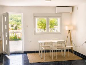 a white dining room with a white table and chairs at VERIGE VIEW Kamenari in Donja Jošica