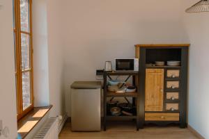 a kitchen with a counter and a microwave and a refrigerator at La batisse du Champ Manneret Maison d'hôte Falaise - logement entier in Falaise