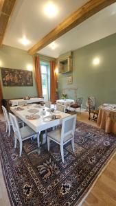 a dining room with a table and chairs on a rug at Manoir de charme Roz Maria - Parc clos in Quintin