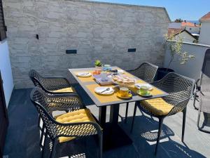 a table and chairs on a patio with food on it at Apartman Luka in Pinezici +17 photos
