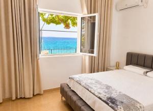a bedroom with a bed and a window with the ocean at Sea View Borsh Albania in Borsh