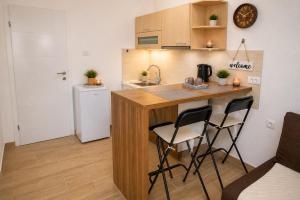 a kitchen with a counter and two chairs at a kitchen island at Charm Apartment-Cathedral area-Self Check-in in Sarajevo