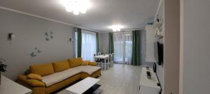 ein Wohnzimmer mit einem gelben Sofa und einem Tisch in der Unterkunft SIL House in Sîntandrei