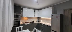 eine Küche mit weißen Schränken und einem Kühlschrank in der Unterkunft SIL House in Sîntandrei + 5 Fotos