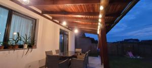 eine Terrasse mit Tisch und Stühlen und einem Fenster in der Unterkunft SIL House in Sîntandrei