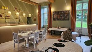 a restaurant with tables and chairs in a room at Manoir de charme Roz Maria - Parc clos in Quintin