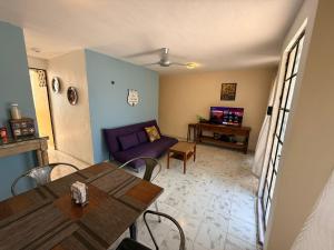 a living room with a table and a purple couch at Casita Escondida in Mérida