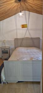 a bedroom with a white bed with a wooden ceiling at Cabanon 50m2 in Méounes-lès-Montrieux