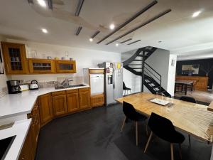 a kitchen with a wooden table and a staircase at Maison de Village 4 chambres in Sabran