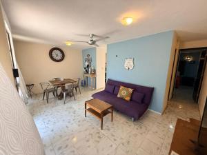 a living room with a purple couch and a table at Casita Escondida in Mérida