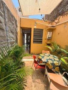 a patio with a table and chairs and a yellow building at Casita Escondida in Mérida