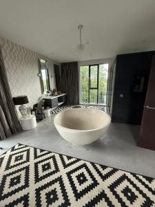 a large white tub in a bathroom with a rug at Old Grain Mill in Eyemouth +70 photos