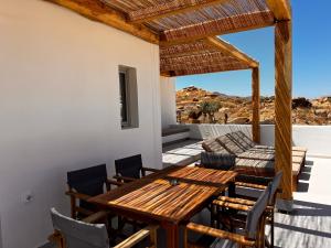 a patio with a wooden table and chairs at Wabi Aegean Villa in Ios Chora