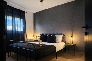 a bedroom with a bed with a black headboard at The Lithos Loft Kyma in Ayía Marína