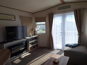 a living room with a flat screen tv next to a window at Perranporth Cornwall in Perranporth