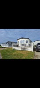 a white house with a white fence and a car at Perranporth Cornwall in Perranporth