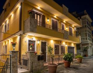 a yellow building with potted plants in front of it at Gloeden House in Taormina