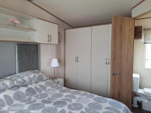 a bedroom with a bed and white cabinets at Perranporth Cornwall in Perranporth