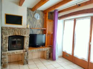 a living room with a fireplace and a tv at Maison 2 chambres, pleine de Charme in Vic-le-Comte