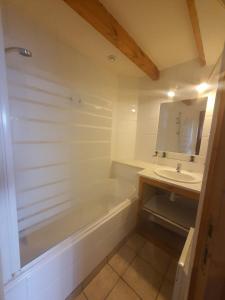 a bathroom with a tub and a sink and a mirror at Maison 2 chambres, pleine de Charme in Vic-le-Comte +24 photos