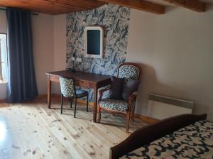 a bedroom with a desk and chairs and a mirror at Maison 2 chambres, pleine de Charme in Vic-le-Comte