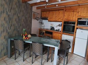a kitchen with a green counter top and some chairs at Maison 2 chambres, pleine de Charme in Vic-le-Comte