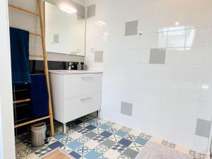 a bathroom with a sink and a tiled floor at Appartement 2 hyper centre d'Agen avec garage et terrasse in Agen