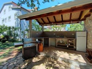 an outdoor kitchen with a grill and a patio at Bed and breakfast Julia in Umag