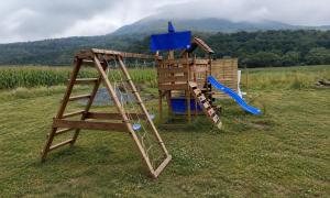 a wooden playground with a ladder and a slide at Rusínska chyža in Ulič