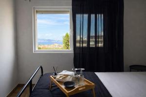 a bedroom with a bed and a window at The Lithos Loft Kyma in Ayía Marína