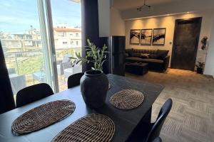 a dining room table with a vase on top of it at The Lithos Loft Kyma in Ayía Marína