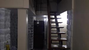 a staircase in a room with a stone wall at Neelprabha Farms in Karjat
