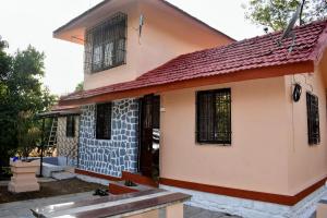 a small house with a red roof at Neelprabha Farms in Karjat