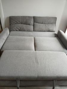 a gray couch in a room with a white wall at La Mignardise - Jardin & Parking in Étretat +19 photos
