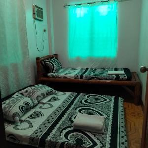 zwei Einzelbetten in einem Zimmer mit Fenster in der Unterkunft Moonlight Seaside Apartments Liloan Cebu in Catarman + 85 Fotos