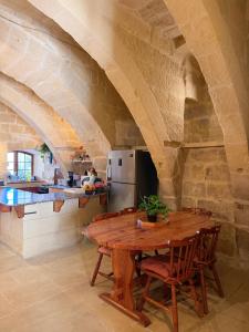 a kitchen with a wooden table in a stone kitchen at Stella & Stone Guesthouse in Għarb