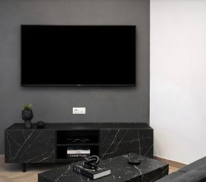 a living room with a flat screen tv on a wall at The Lithos Loft Kyma in Ayía Marína