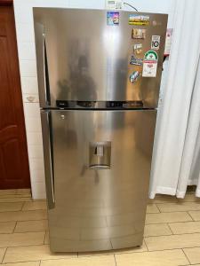 a stainless steel refrigerator with magnets and stickers on it at Sweet Haven - Sports Rd in Westlands