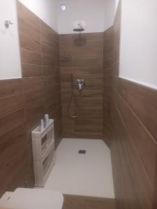 a bathroom with a shower with wooden walls at Baby Home in Dalmine