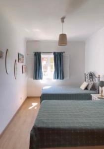 a bedroom with two beds and a window at Praia Verde Residence in Praia Verde