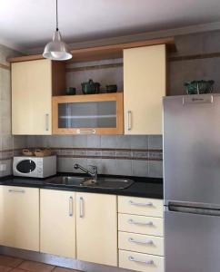a kitchen with a sink and a refrigerator at Praia Verde Residence in Praia Verde +26 photos