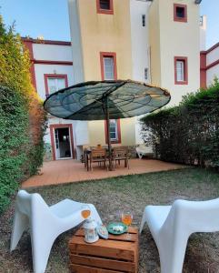 a patio with a table and chairs and an umbrella at Praia Verde Residence in Praia Verde