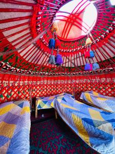 a room with two beds in a red tent at Azamat Nomad Camp in Song-Kul