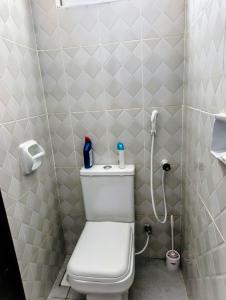 a small bathroom with a toilet and a shower at Dorado Homestay, Chaani in Mombasa +13 photos