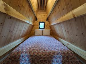 a bedroom in a wooden cabin with a bed in it at Tipi Big Foot in Vivy