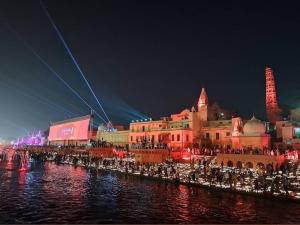 a city lit up at night next to the water at Abhishek chand kaushik guest House in Ayodhya