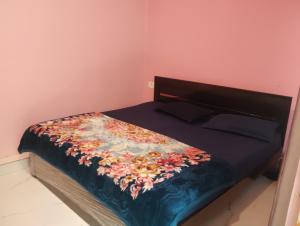 a bedroom with a bed with a floral quilt on it at Abhishek chand kaushik guest House in Ayodhya