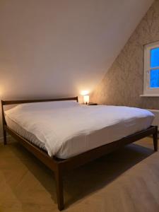 a large bed in a bedroom with a window at Riekje in Lage Zwaluwe