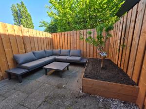 a blue couch sitting on a patio next to a fence at Riekje in Lage Zwaluwe