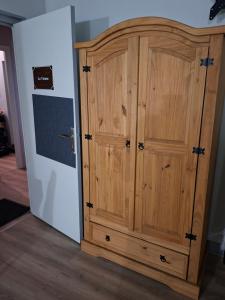 a wooden cabinet in a room with a bedroom at Le Café D Ici in Saillat-sur-Vienne